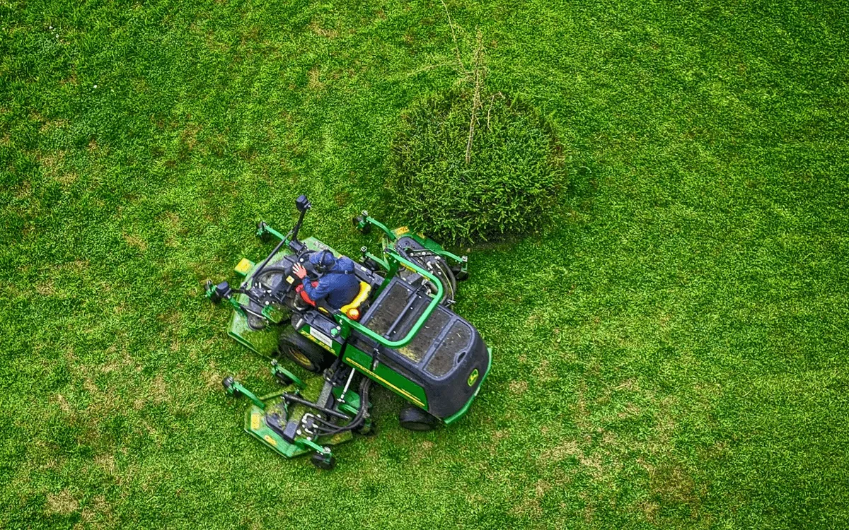 Aerial view of commercial lawn mower on lush green grass